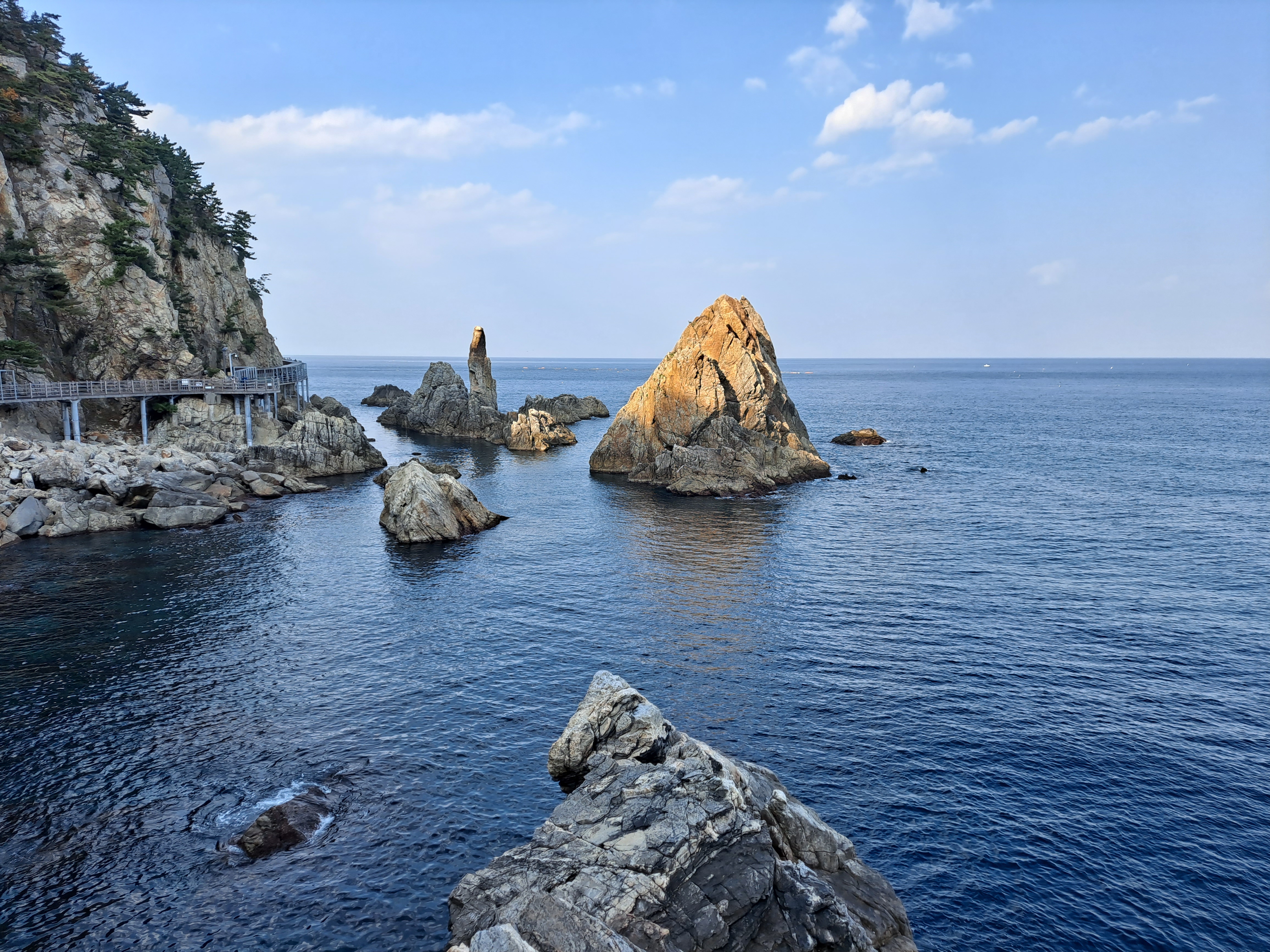 从吊桥高处俯瞰烛台岩与望夫岩相依的海岸构图。